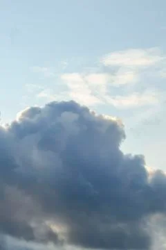 Amazing dark grey and white clouds during the sunset contrasted against a lig Stock Photos