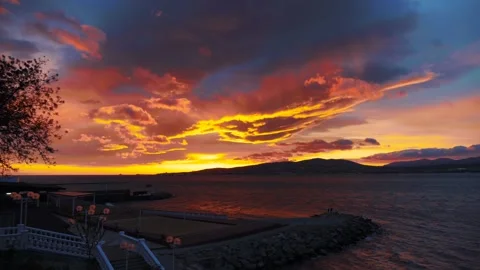 Amazing dramatic colorful sunset with bright cloudy sky over sea bay panorama Stock Footage 192407313