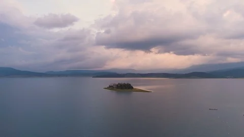 Amazing drone view of sunset over lake island with vibrant clouds Stock Footage 112057367