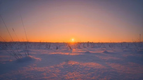 Amazing empty winter field illuminating at beautiful yellow sunset or sunrise 動画素材 101464689