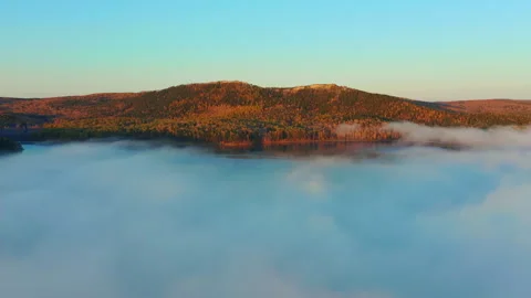 Amazing flying through clouds above pond to the mountain range on horizon Stock Footage 270054056