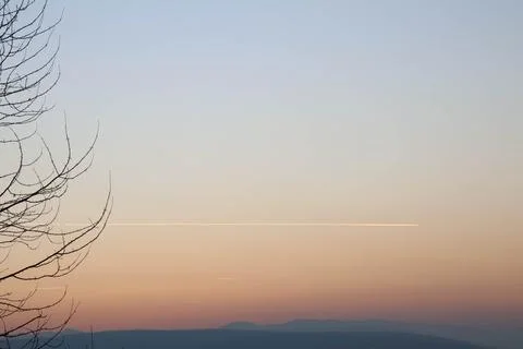 Amazing gradient sunset with trace of plane. Stock Photos