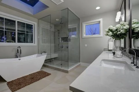 Amazing gray master bathroom with large glass walk-in shower, freestanding tub a Stock Photos
