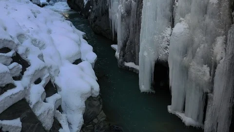 Amazing icy cliffs with snow on a side, near the mountain river, 4k Stock Footage 106441002