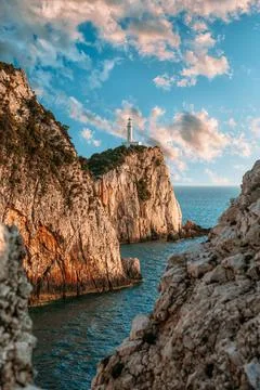 Amazing lighthouse surrounded by steep cliffs at the most southen part of Lef Stock Photos