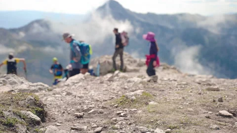 Amazing mountains peak with sharp ranges and raising fog, blurred people in Stockbeeldmateriaal 224777315