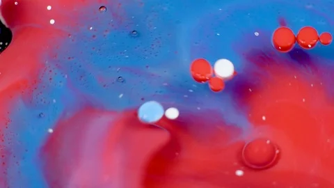 Amazing red and blue bubbles of paint on the oil surface. Paint in oil. Video stock 105188765