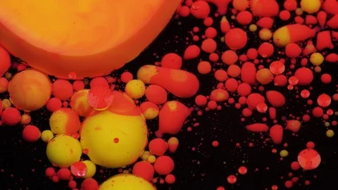 Amazing red and yellow bubbles of paint on the oil surface. Paint in oil. 動画素材 105192062