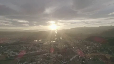 Amazing red sun rays reaching over a small industrial town in the valley, 4K Stock-Footage 73694323