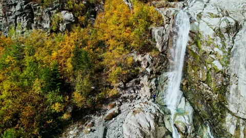 Amazing Small Waterfall In Cliff Of High Mountain With Forest On Slope, Aerial Stock Footage 254287236