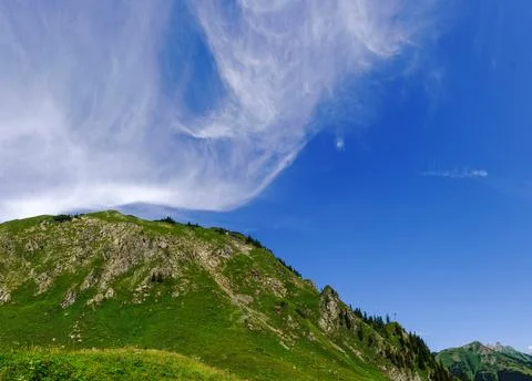 Amazing soft white cloud on deep blue sky with a green mountain panorama Stock Photos