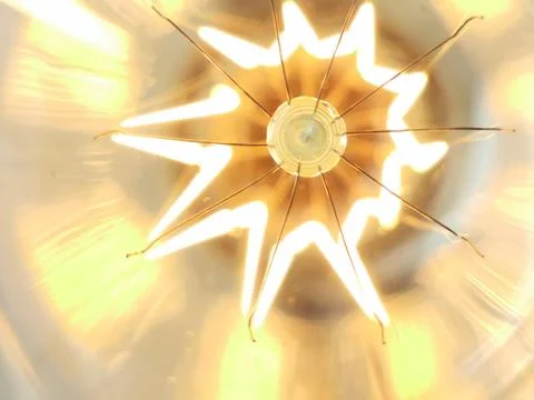 Amazing spiral electric current inside a retro crystal clear light bulb. Stock Photos