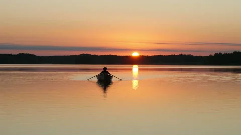 Amazing sun path reflection over the lake and silhouette of man rowing on boat 스톡 동영상 97585742
