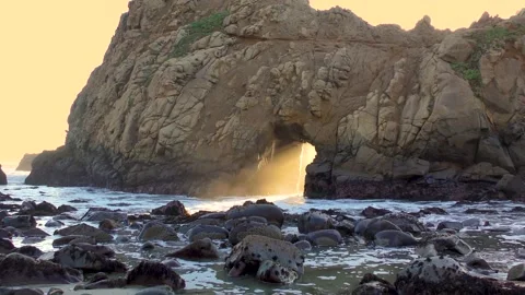 Amazing sunset light through rock sea stack in ocean waters of California Stock Footage 169405051