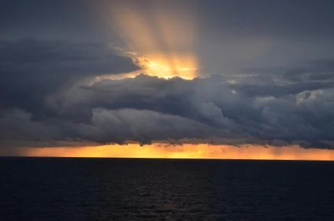 Amazing sunset with long rays piercing the clouds Stock Photos