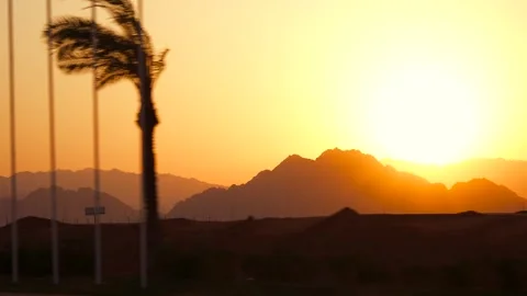 Amazing sunset in the mountains. Side view from the fast moving car by the road Stock Footage 251885759