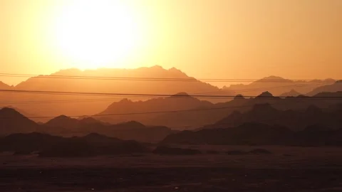 Amazing sunset in the mountains. Side view from the fast moving car by the road Stock Footage 251885822