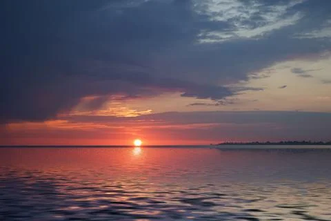 Amazing sunset on the ocean. View of dramatic cloudy sky and reflection of .. Stock Photos