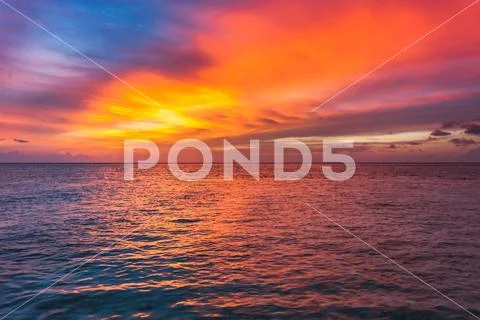 Amazing sunset over the ocean. Colorful reflection in the water. Stock Photos