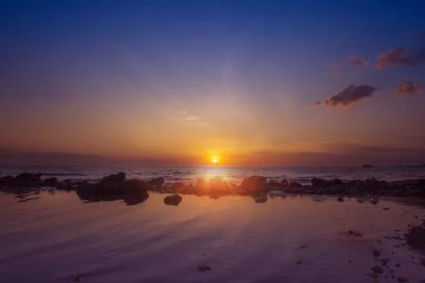 Amazing sunset view at the beach with reflection.Image contained Noise due to Stock Photos