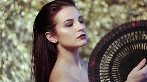 Amazing supermodel with a fan in hand Stock Footage 75733229