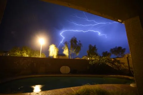 Amazing Thunders storm over a pool in the backyard of a house Stock Photos