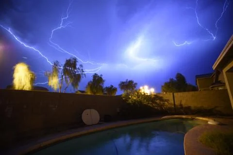 Amazing Thunders storm over a pool in the backyard of a house Stock Photos