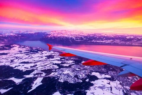 Amazing view from the airplane window during the sunset over mountains in Stock Photos