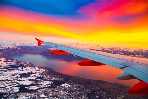 Amazing view from the airplane window during the sunset over mountains in Stock Photos