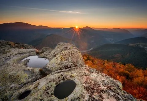 Amazing view with first rays at the top of a rock Stock Photos