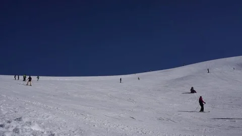 Amazing view of snow capped hill with skiers and snowboarders on bright day Video stock 81550163