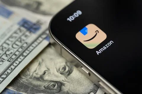Amazon app on smartphone screen with dollar background Stock Photos