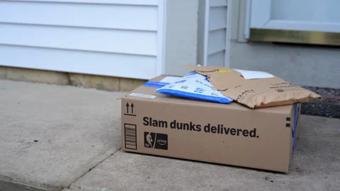 Amazon delivery package with padded envelopes left on a residential doorstep. Stock Footage 330985939