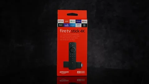 Amazon Fire TV Stick 4K with Alexa Voice Remote in its red box on black Stock Footage 310067527