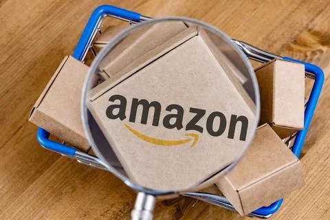 Amazon logo on box under magnifying glass in shopping cart Stock Illustration