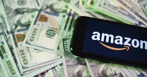 Amazon Logo on iphone surrounded by $100 Bills. Amazon Profits Layout. Stock Footage 169008647