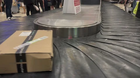 Amazon package box arriving via flight terminal moving carousel and gets collect Vidéo 227881661