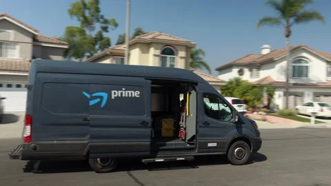 Amazon Prime delivery van driving through a suburban neighborhood Stock Footage 140680283