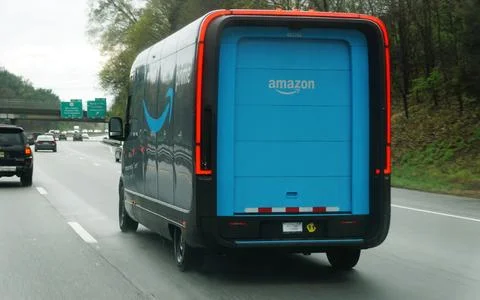 Amazon Prime delivery van on highway featuring blue rear door, branding, an.. Stock Photos