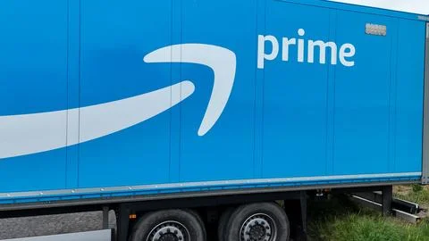 Amazon Prime logistics trailer positioned near a rural industrial area with.. Stock Photos