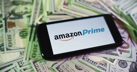 Amazon Prime Logo on iphone surrounded by $100 Bills. Amazon Profits Layout Stock Footage 169006068