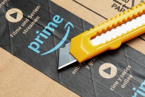 Amazon Prime parcel with utility knife or box cutter for unpacking close up Stock Photos