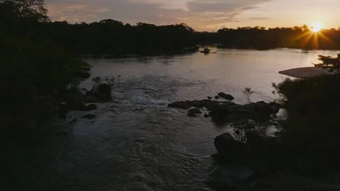 Amazon rainforest landscape at sunset, with a river flowing through dense Stock Footage 342863636