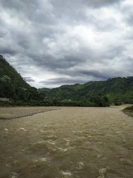 Amazon river with the background full of green mountains and blue sky with cl Photos