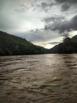 Amazon river with the background full of green mountains and blue sky with cl Photos