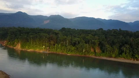 Amazon River on Edge of the Rainforest with Dramatic Hills and Clouds Stock Footage 136762882