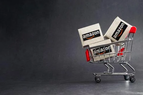 Amazon shipping packages boxes and shopping cart on black background 스톡 사진