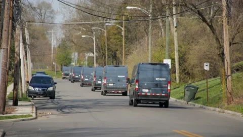 Amazon vans or Amazon trucks pull on a city street. A long line of Amazon Stock Footage 151878267