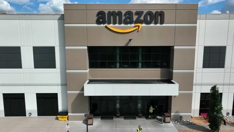 Amazon warehouse building and close-up of aerial. Employees walk in Stock Footage 205185136
