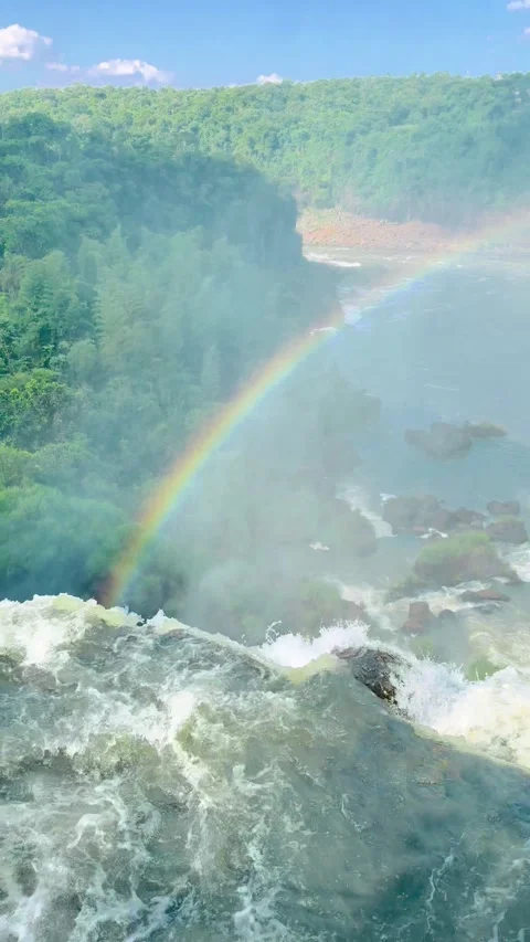 Amazonian waterfall cascading into a lush, green forest with a visible rainbow Stock Footage 276618440
